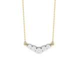 A delicate gold chain necklace featuring five small, round-cut clear stones arranged in a gentle arc on a white background.